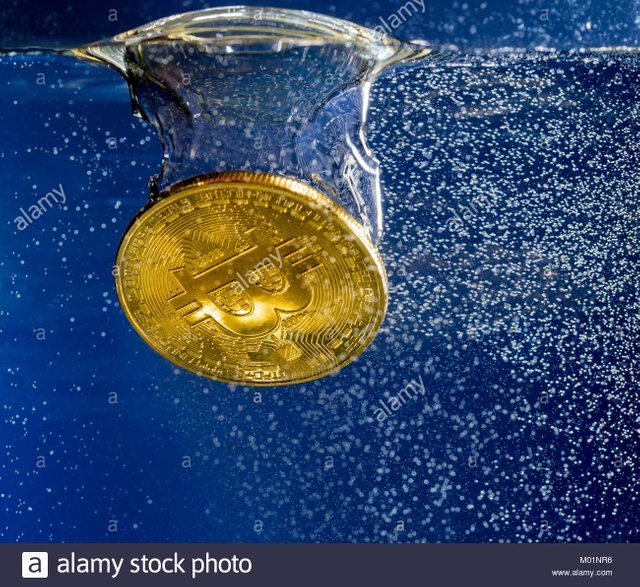 bitcoin-sinking-through-water-as-illustration-of-falling-price-M01NR6.jpg