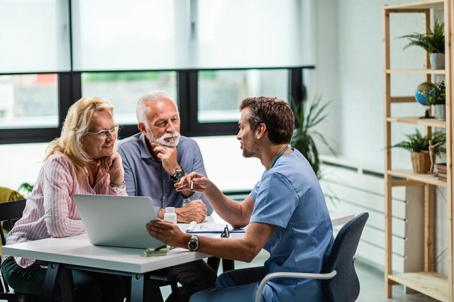 happy-mature-couple-their-doctor-communicating-while-using-laptop-during-medical-appointment_637285-1485.jpg