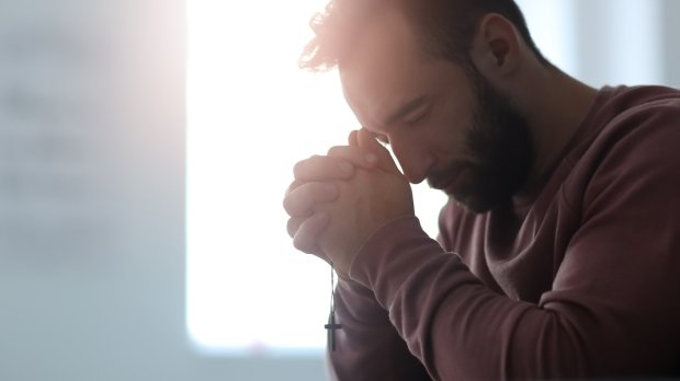 web2-religious-young-man-praying-to-god-at-home-shutterstock_1221529525.jpg