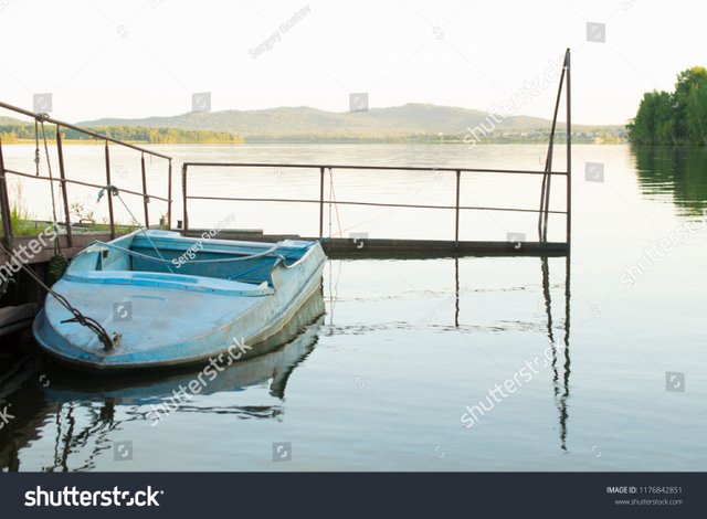 stock-photo-small-old-fishing-boat-at-the-pier-1176842851.jpg