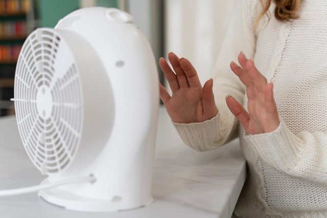 woman-warming-up-hands-near-heater_23-2149335130.jpg