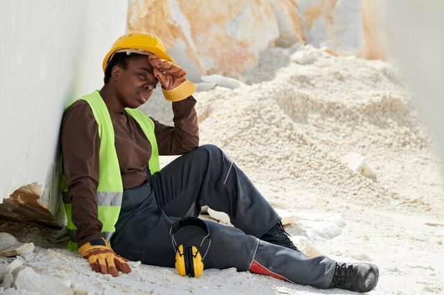 young-tired-black-woman-workwear-sitting-ground-by-huge-marble-rock_274679-39328.jpg