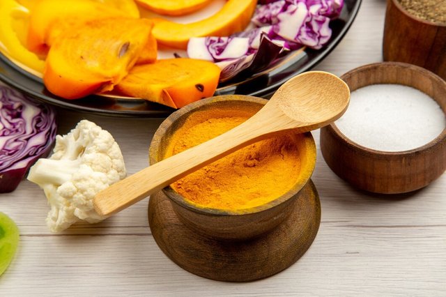 bottom-half-view-cut-vegetables-fruits-pumpkin-bell-peppers-persimmon-red-cabbage-black-plate-spice-small-bowls-wooden-spoon-wooden-table_140725-102531 (1).jpg