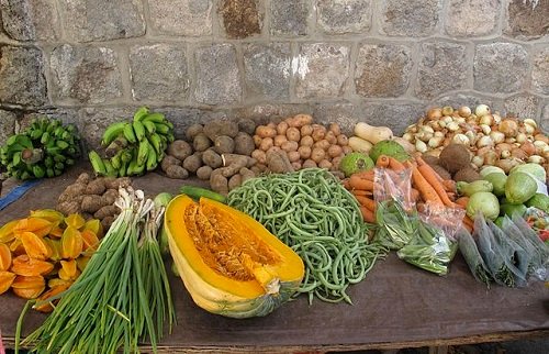 A_table_with_vegetables_for_sale_outside_the_Market_in_Charlestown,_Nevis,_West_Indies,_up_against_a_cut-stone_wall.JPG
