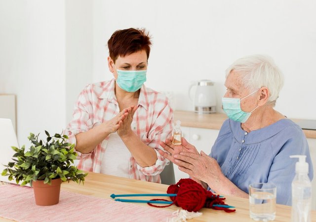 elder-women-disinfecting-their-hands-while-home_23-2148492252.jpg