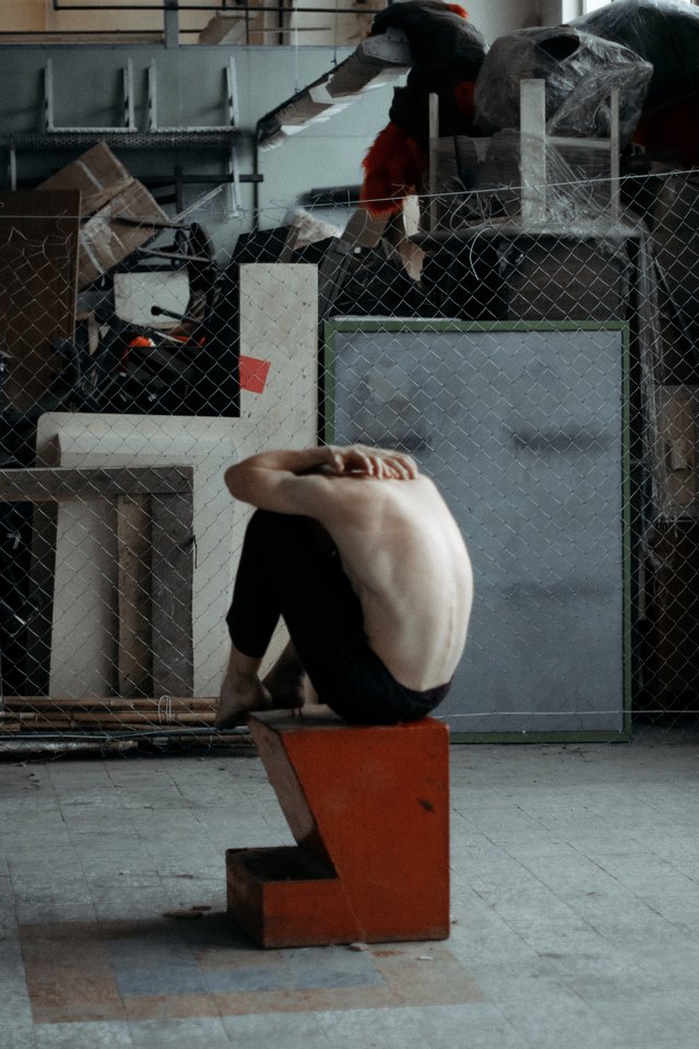 topless-man-sitting-on-brown-and-black-block-1987140.jpg