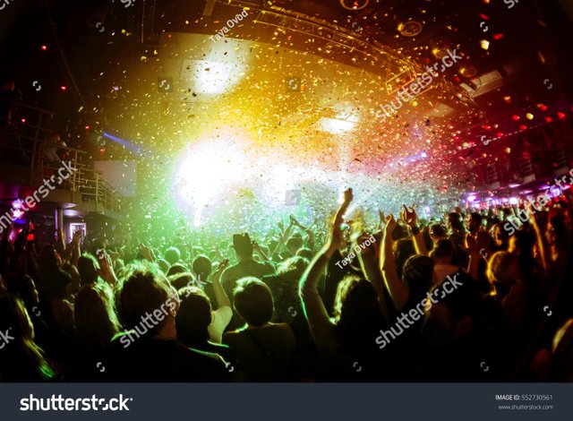 stock-photo-shiny-rainbow-confetti-during-the-concert-and-the-crowd-of-people-silhouettes-with-their-hands-up-552730561.jpeg