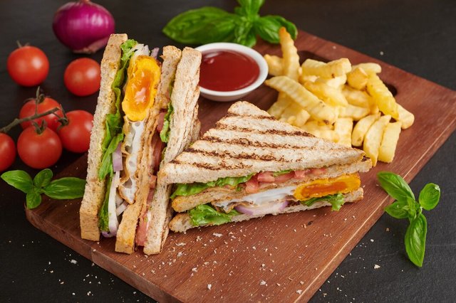 grilled-sandwich-with-bacon-fried-egg-tomato-lettuce-served-wooden-cutting-board_1150-42571.jpg