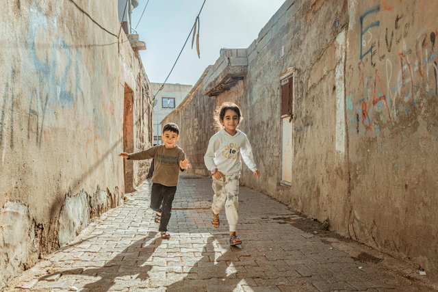 free-photo-of-children-running-through-street-past-abandoned-building.jpeg