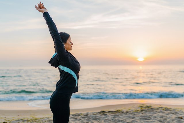 young-attractive-slim-woman-doing-sport-exercises-morning-sunrise-beach-sports-wear-healthy-lifestyle-listening-music-earphones-making-stretching.jpg