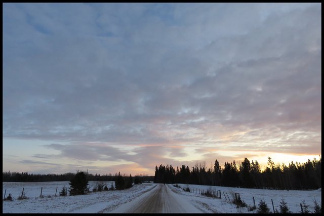 light clouds touched by sunset expanding over roadway.JPG