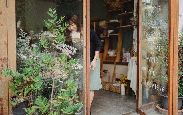 asian-florist-turning-signboard-on-store-wall.jpg