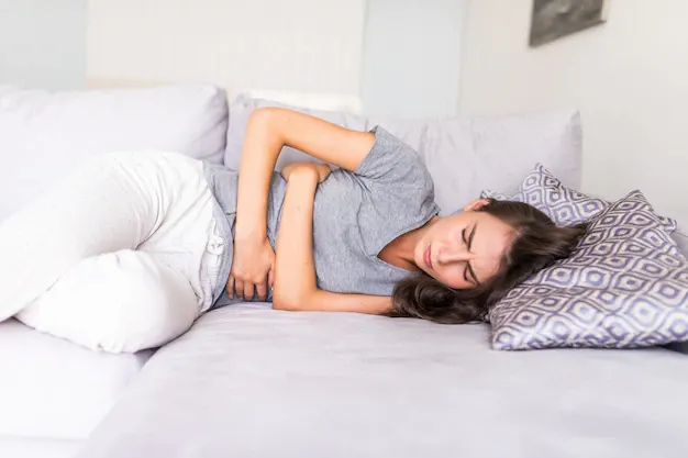 young-woman-haviing-abdominal-pain-because-menstruation-lying-couch-holding-her-stomach_231208-689.webp