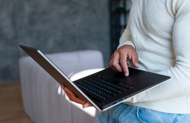 close-up-standing-man-using-laptop.jpeg