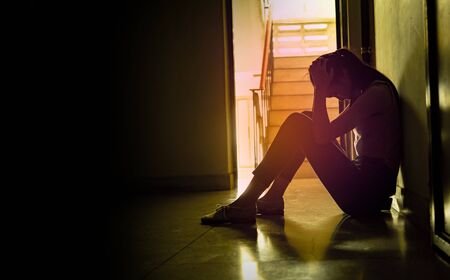 129963866-silhouette-of-a-sad-young-girl-sitting-in-the-dark-leaning-against-the-wall-domestic-violence-family.jpg