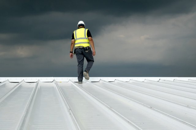 Man-Conducting-a-Roof-Inspection-of-a-Commercial-Metal-Roof-1030x687.jpg