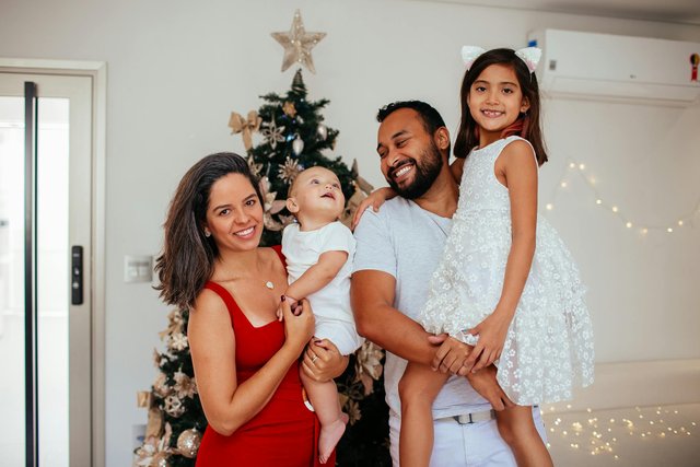 free-photo-of-a-family-poses-for-a-photo-in-front-of-a-christmas-tree.jpeg