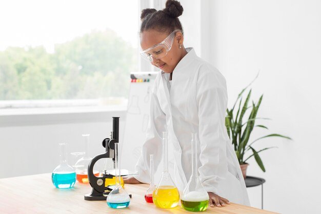 side-view-young-girl-scientist-lab-coat-looking-microscope_23-2148571301.jpg