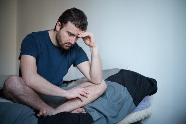 depressed-and-anxious-man-sitting-cross-legged-on-bed.jpg