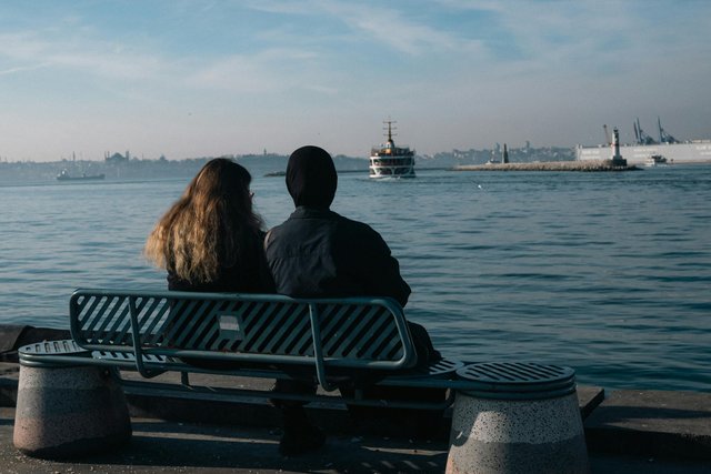 free-photo-of-couple-sitting-on-seaside-bench-watching-boats.jpeg