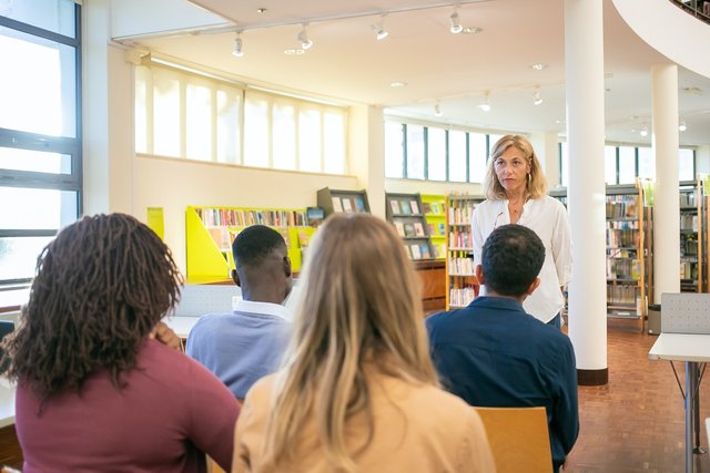 https://www.pexels.com/photo/multiethnic-students-listening-lecturer-in-university-5940842/