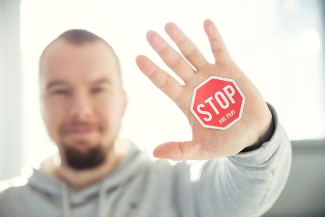 photography-of-a-persons-hand-with-stop-signage-823301.jpg