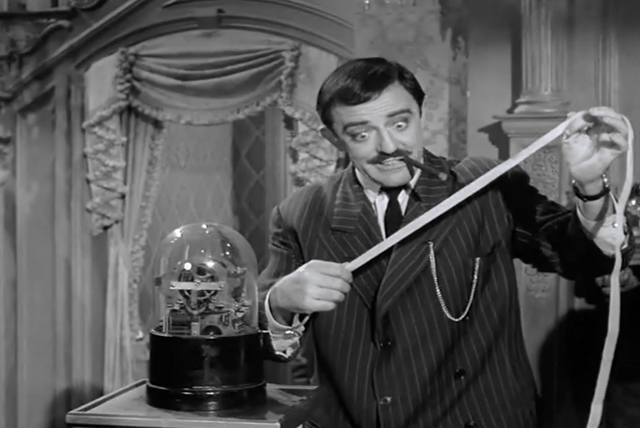 Gomez Addams inspecting a stock ticker