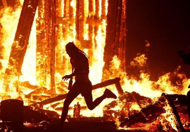 Burning-Man-participant-runs-into-the-flames-of-the-Man-Burn-at-the-Burning-Ma.jpg