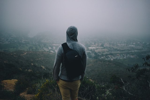 hooded-man-with-backpack-looking-over-horizon.jpg