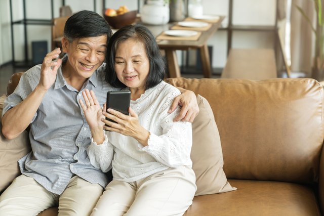 happy-senior-old-asian-lover-couple-holding-smartphone-looking-cellphone-screen-laughing-casual-relaxing-sit-sofa-together-smiling-elder-mature-grandparents-family-embracing-lifestyle.jpg