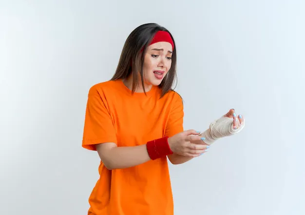 aching-young-sporty-woman-wearing-headband-wristbands-touching-looking-injured-wrist-wrapped-bandage-isolated_141793-68645.webp