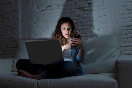58106360-internet-and-social-network-addict-woman-using-laptop-computer-and-mobile-phone-at-the-same-time-sit.jpg