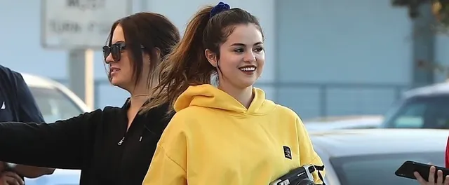 selena-gomez-green-biker-shorts-and-yellow-sweatshirt.webp