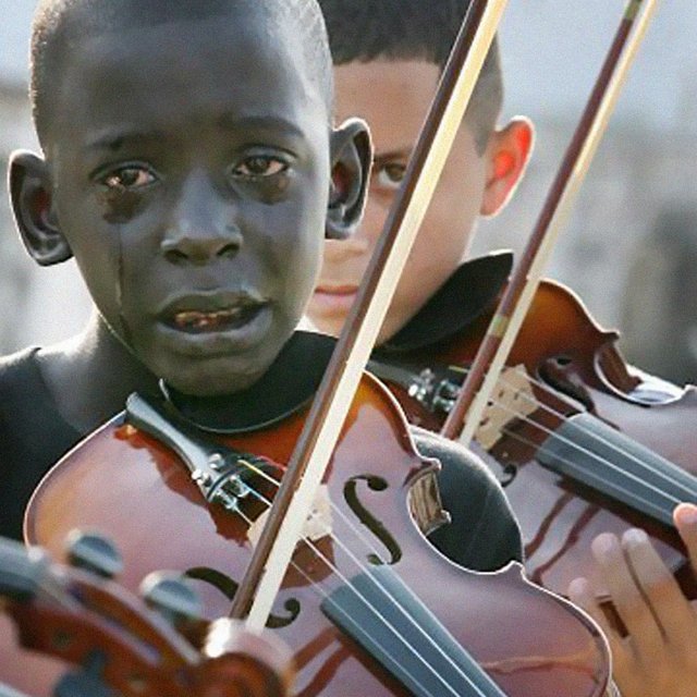5. Diego Frazão Torquato, 12 year old Brazilian playing the violin at his teacher’s funeral. The teacher had helped him escape poverty and violence through music.jpg
