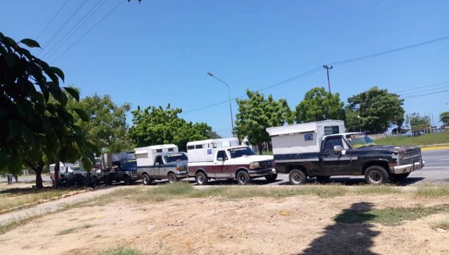 Cola de camionetas en la calle.jpg