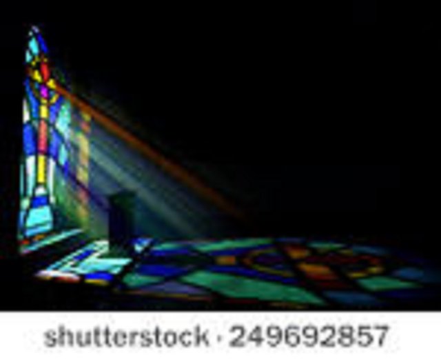 Interior de iglesia antigua iluminado por rayos de sol que entran a través de una ventana colorida