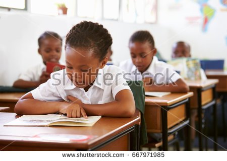 stock-photo-schoolgirl-reading-at-her-desk-in-elementary-school-lesson-667971985.jpg