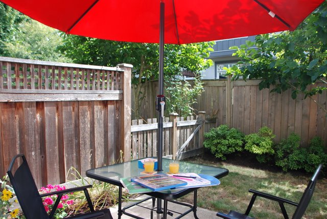 Airbnb short-term rental Surrey Outdoor Red Umbrella Patio Set in backyard, Inviting Orange Juice & Colouring Book.JPG