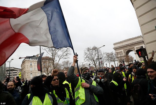 Demonstrators_wearing_yellow_vests_march_down_the_Champs_Elysees-a.jpg
