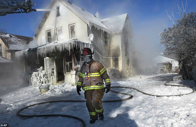 9199024-6650115-A_firefighter_walks_past_an_ice_encrusted_home_after_an_early_mo-a-120_1548887097819.jpg