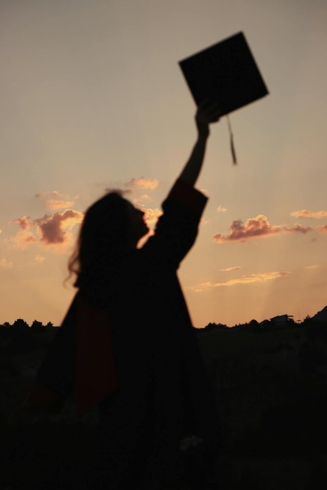 free-photo-of-silhouette-of-woman-holding-up-graduation-cap-at-sunset.jpeg