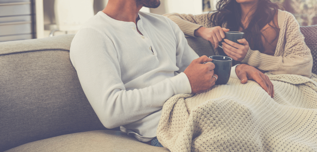 couple-sitting-on-sofa-getting-cozy-1024x493-1.png