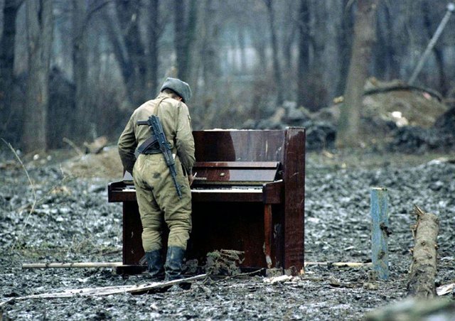 6. A Russian soldier playing an abandoned piano in Chechnya in 1994.jpg