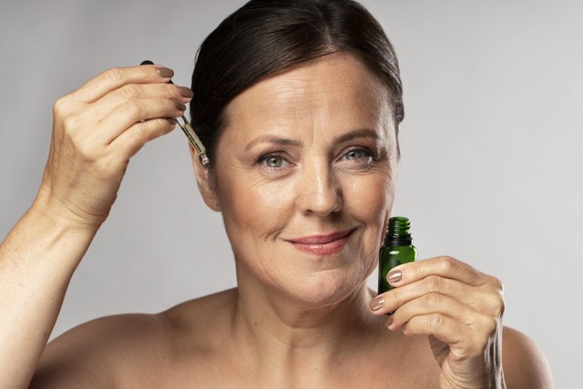 smiley-elder-woman-using-serum-her-face-min.jpg