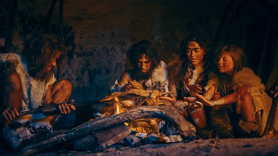 neanderthal-or-homo-sapiens-family-cooking-animal-meat-over-bonfire-and-then-eating-it-tribe.jpg