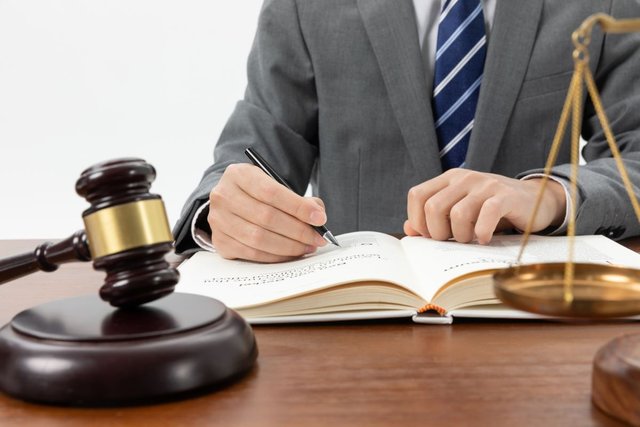 closeup-shot-person-writing-book-with-gavel-table1.jpg