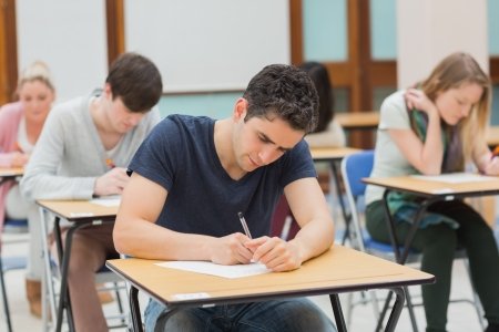 16065871-los-estudiantes-que-se-sientan-en-una-sala-de-examen-haciendo-un-examen-en-la-universidad.jpg