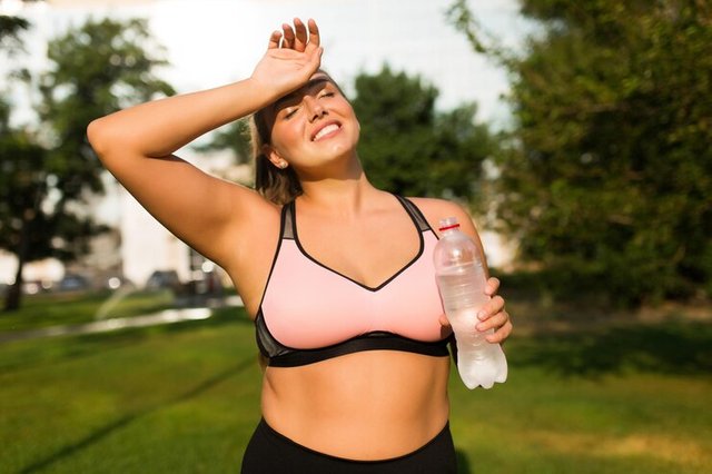 young-pretty-smiling-plus-size-woman-pink-sporty-top-holding-bottle-pure-water-hand-dreamily-closing-eyes-while-spending-time-city-park_574295-4876.jpg