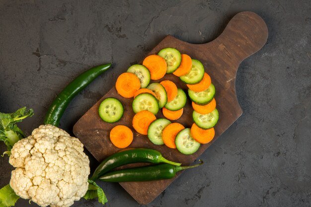 top-carrot-cucumber-slices-cauliflower-wooden-cutting-board-dark_140725-12311.jpg