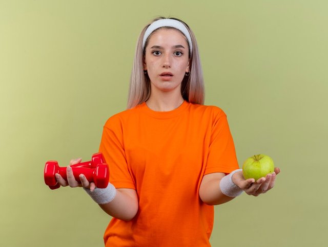 impressed-young-caucasian-sporty-girl-with-braces-wearing-headband-wristbands-holds-dumbbells-apple_141793-99376.jpg
